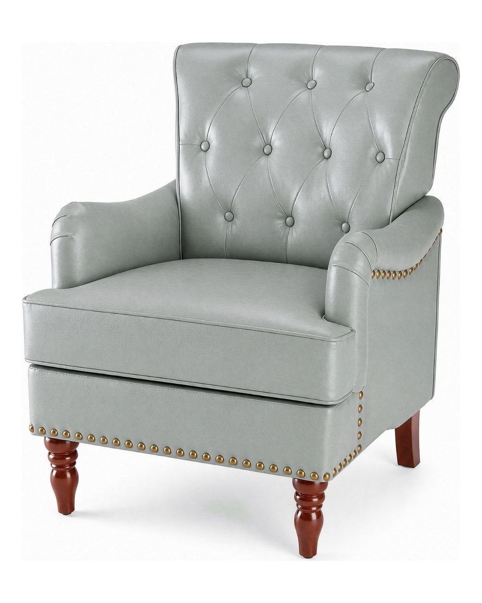 A grey button-tufted armchair with brass nailhead trim and turned wooden legs, photographed on a pale background.